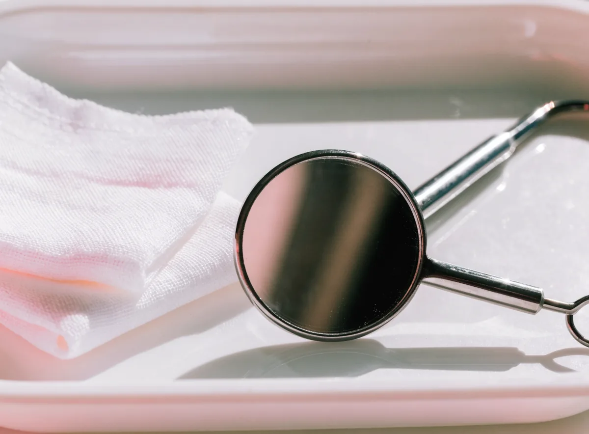 Mouth mirror and gauze on a preventive care tray (illustrative)