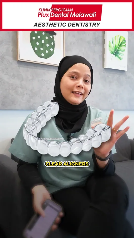 Dr Syaza holding a set of clear aligner trays