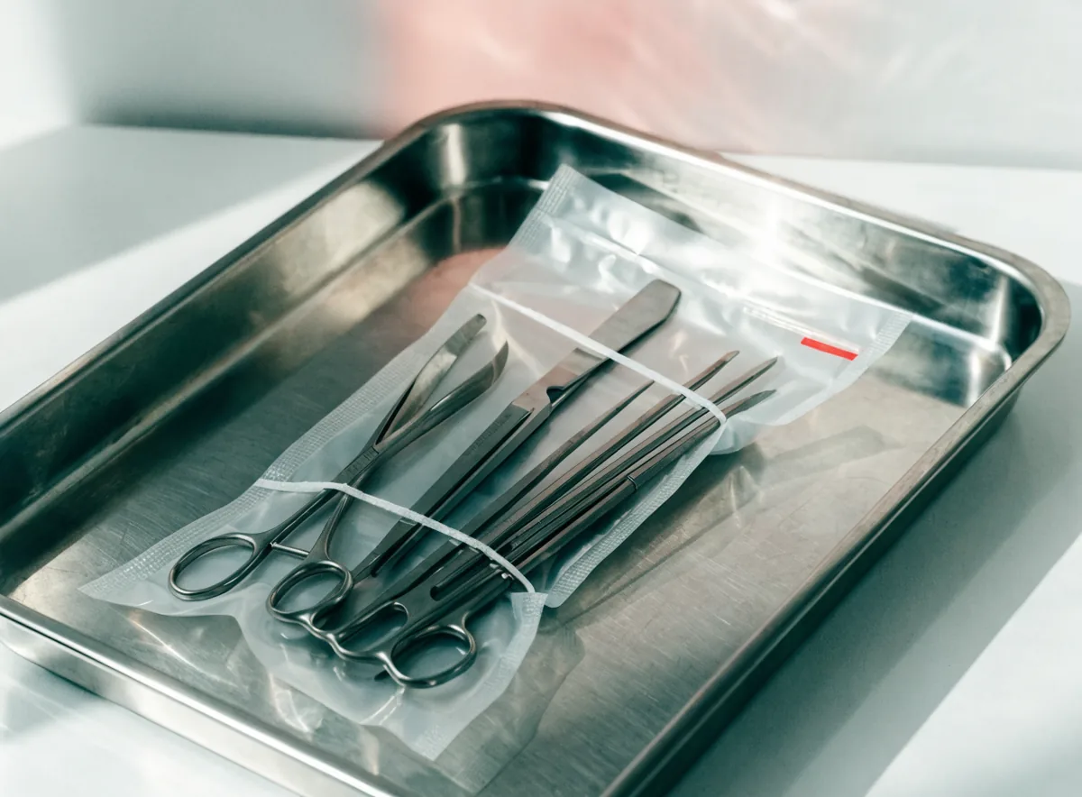 Pouched oral surgery instruments on a steel tray (illustrative)